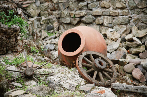 pottery-jug-old-wooden-wheel-near-stone-wall (1)